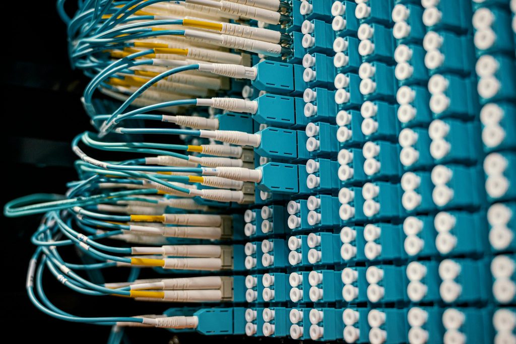 Anasayfa 18 Close-up of a network patch panel with connected blue fiber optic cables.